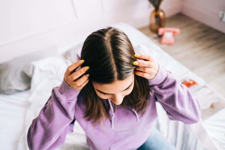 imagem do topo da cabeça de uma mulher branca representando a queda de cabelo