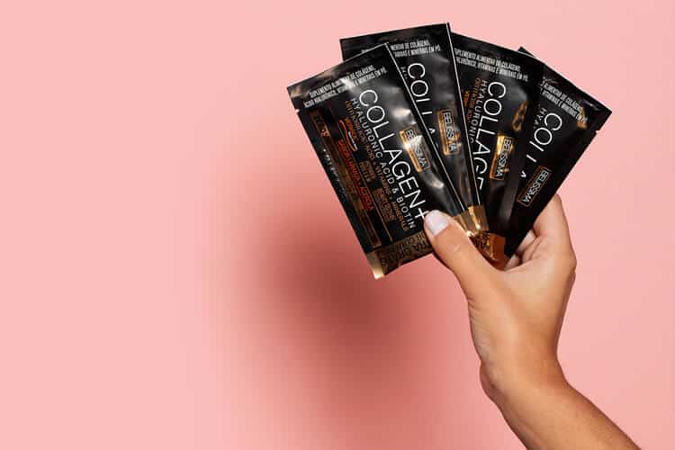 Mão branca segura quatro sachês de Collagen+, nutricosmético interessante para pele ressecada