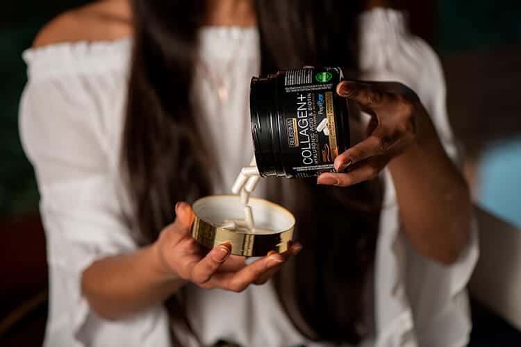 mulher segurando pote de collagen+, um nutricosmético indicado para quem quer saber como cuidar das unhas